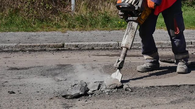 ouvrier de la voirie en action avec un marteau-piqueur