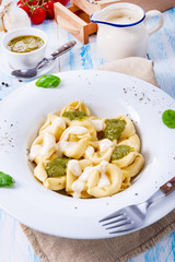 Tortellini di formaggio with basil pesto and cheese sauce