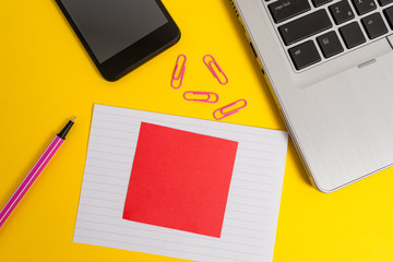 Trendy laptop smartphone marker paper sheet note clips colored background