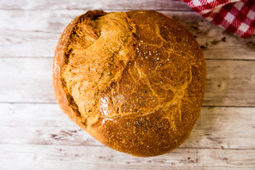 freshly baked bread on wooden kitchen table, top view