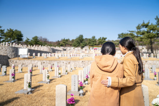Korean people infront of tombstone in tomb of Korea war