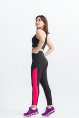 Fototapeta premium Woman with dark hair in a sportswear stretching in a gym. Exercising for weight loss