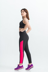 Fototapeta premium Woman with dark hair in a sportswear stretching in a gym. Exercising for weight loss