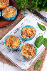 Muffins with spinach and cheese on a white wooden board.