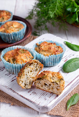 Muffins with spinach and cheese on a white wooden board.