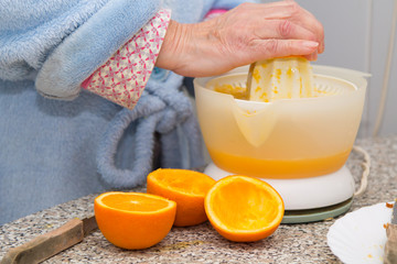woman making orange juice with juicer