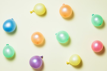 Birthday party bright pastel background with streamers, confetti, balloons on yellow backround. Top view, flat lay