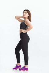 Fototapeta premium Woman with dark hair in a sportswear stretching in a gym. Exercising for weight loss