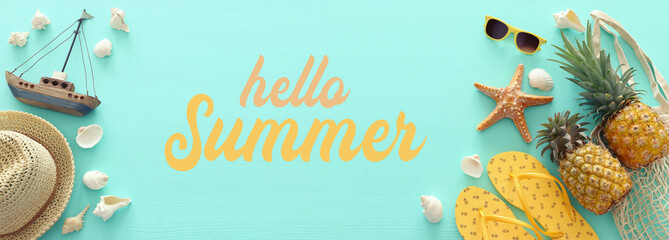 Ripe pineapple and beach sea life style objects over pastel mint blue wooden background. Tropical...