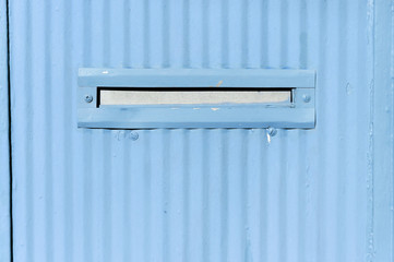 Old letterbox or mailbox in the retro abstract blue metal gate door traditional way of delivering letters and mail to the house close up