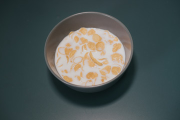 Cornflake cereal in the bowl with full cream milk.