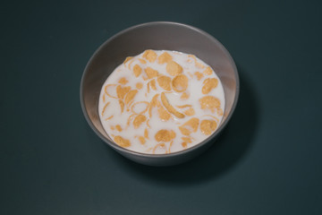 Cornflake cereal in the bowl with full cream milk.