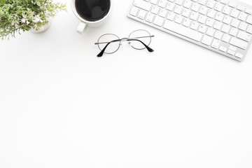 White office desk table with computer keyboard, eye glasses and cup of coffee. Top view with copy space, flat lay.