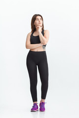Fototapeta na wymiar Woman with dark hair in a sportswear stretching in a gym. Exercising for weight loss