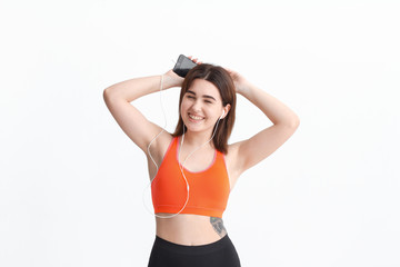 Fototapeta na wymiar Young brunette woman in a sportswear listening to music during workout.
