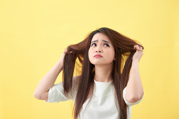 Fototapeta premium Woman holding damaged hair the hand and looking. Isolated portrait