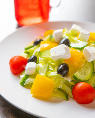 Greek salad on a white plate in a restaurant