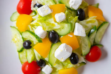 Fototapeta na wymiar Greek salad on a white plate in a restaurant