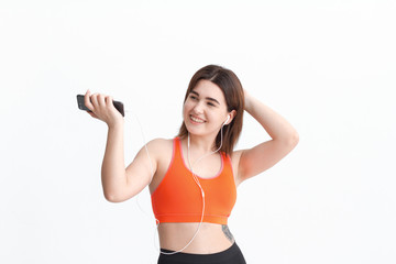 Young brunette woman in a sportswear listening to music during workout.
