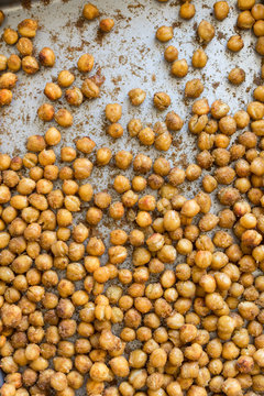 Top view of frying pan/baking sheet with paprika and cumin spicy roasted chickpeas. Close up overhead, vertical. 