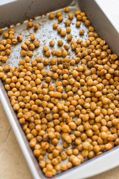 Top view of frying pan/baking sheet with paprika and cumin spicy roasted chickpeas. Close up overhead, vertical. 