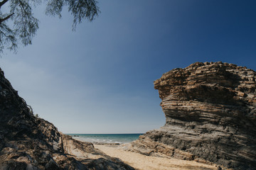Beautiful tropical island beach scenery with palm trees,nature rock formation and blue sky background.