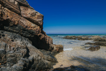 Beautiful tropical island beach scenery with palm trees,nature rock formation and blue sky background.