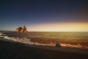 Beautiful tropical island beach scenery with palm trees,huge nature rock formation and blue sky background.