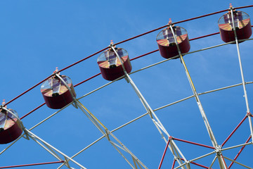 Cabins of a ferris wheel against the blue sky. City Park. Attraction and entertainment.