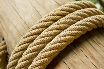 Obraz premium A wooden cracked log, tied with three coils of thick hemp rope.