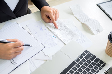 business woman accountant or banker making calculations Bills. doing finances in the office, economy concept through laptop