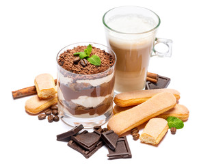 Classic tiramisu dessert in a glass, savoiardi cookies and cup of coffee isolated on a white