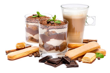 Classic tiramisu dessert in a glass, savoiardi cookies and cup of coffee isolated on a white