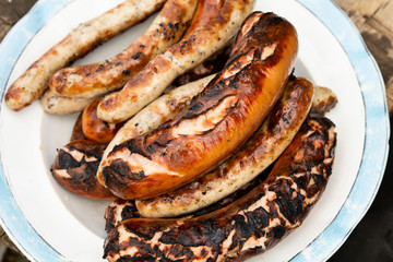 grilled sausages on the grill in the plate.