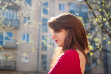 Side view of beautiful cheerful girl with cute sensual lips enjoying spring in the city during sunny day. Lifestyle concept. Face are not visible