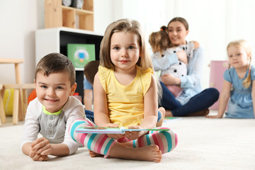 Cute little children with book indoors, space for text. Learning and playing