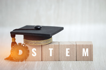 Ideas for STEM Education about science, technology, engineering, mathematics word on sign wood Graduation cap with wooden blocks tower and blur global, Copy space for text on background