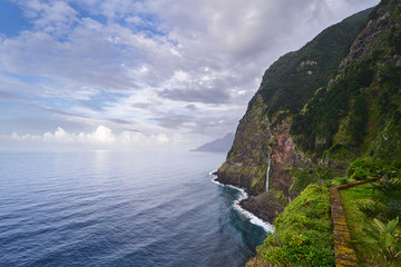 Fototapeta premium Beautiful view of a waterfall near the blue atlantic ocean and nice sky in Madeira