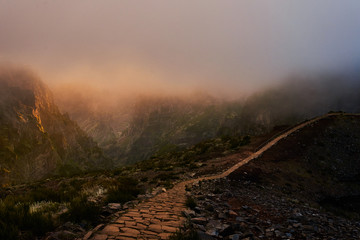 Sunset on mountain with gold sky and trail leading to clouds, pico de arieiro, Madeira
