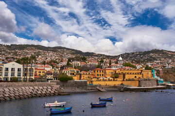 Harbour with boasts, yellow building and dramatic sky