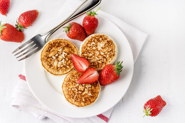 ThreeTasty Homemade Cottage Cheese Pancakes with Strawberries on White Plate Tasty Healthy Diey Breakfast Breakfast Concept Top View Flat Lay Copy Space