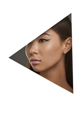 Cropped side geometric portrait of Asian girl with black flicks. The woman with dark hair is wearing square-shaped stud earrings with marbled insert, looking to the side behind triangle foreground.