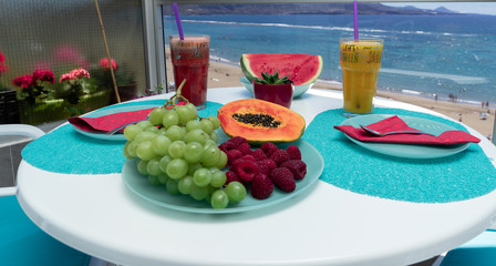 Healthy fruits shake and breakfast on the beach