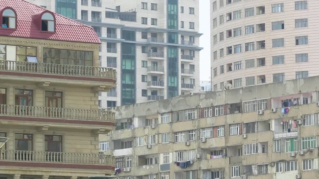 Pan over soviet architecture and modern Azerbaijani apartment building - covered balconies and lots if air conditioning units on the balconies - real estate investment in Baku