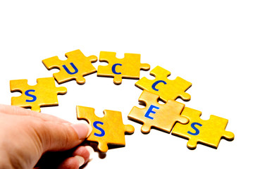 man building the word success with pieces of puzzle 