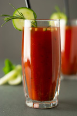 Glasses of tasty tomato juice isolated on gray table