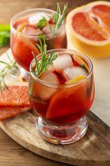 Two glasses of summer drink. Pink refreshing cold cocktail. Wooden table.