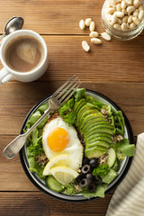 Healthy food. Eggs, quinoa, avocado, green salad, black olives. Wooden table. diet, lose weight.