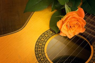 Romantic music concept with close up to guitar and beautiful orange rose  © starblue