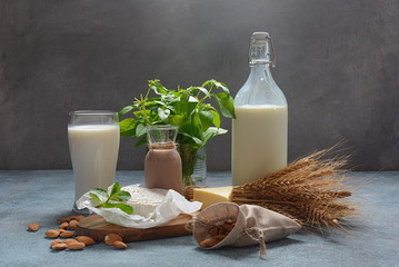 Almond milk in glass bottles with almond nuts on background. Vegan diary concept. Shavuot jewish...